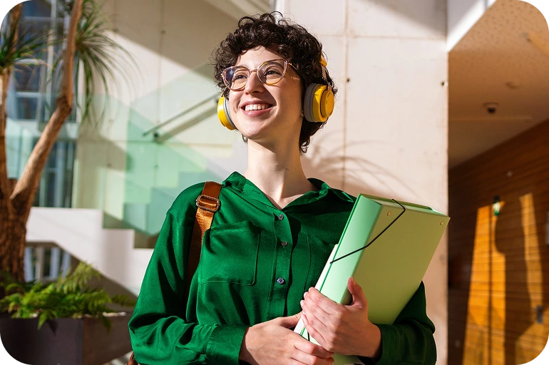 Smiling student in green hoodie holding a folder