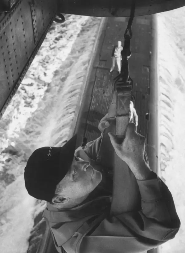 Admiral Charles R. Brown is lowered from a helicopter onto a submarine, during a 1956 inspection of a Mediterranean fleet.