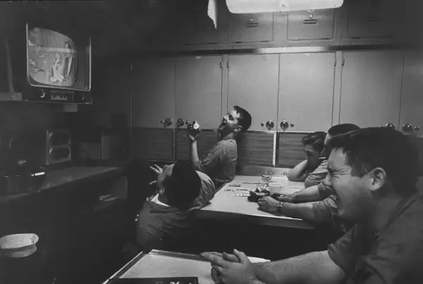 Men watch  at a submarine base and school.