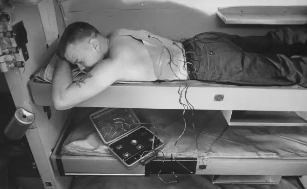 A crew member aboard the submarine  uses an electronic device to massage his muscles and maintain fitness during a voyage.