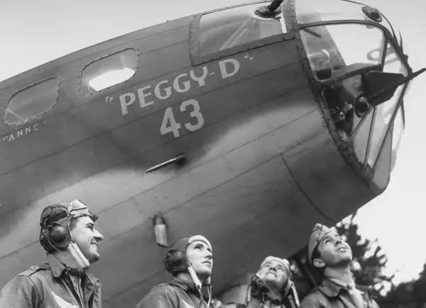 Four U.S. airmen pose by their B-17 in southern England, 1942.
