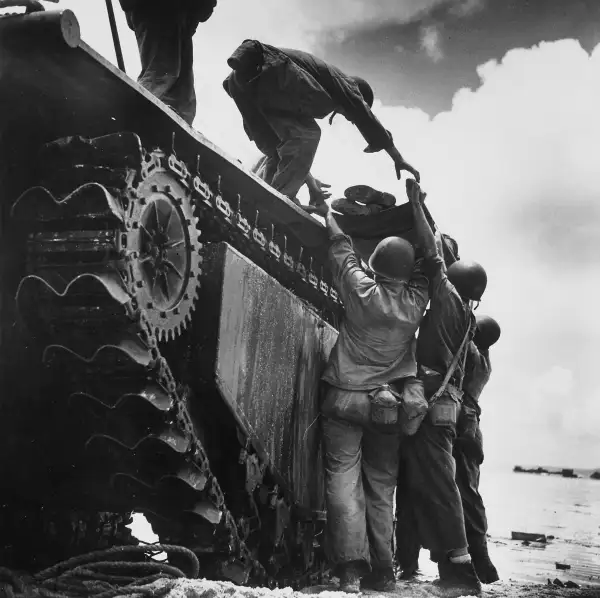A wounded American Marine is loaded onto an  alligator  amphibious vehicle for evacuation during fighting at Guam's Asan Point in 1944.  W. Eugene Smith's deceptively simple image (reminiscent, in its skyward-reaching composition, of Gericault's masterpiece,  The Raft of the Medusa ) perfectly contrasts the strength, camaraderie, and gentleness of the troops with the mute, utilitarian machinery of war.