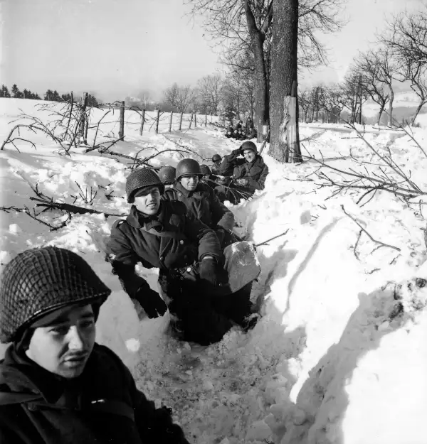 American soldiers in a snowy ditch in Belgium during the Battle of the Bulge
