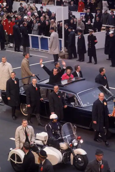 On January 20, 1969, surrounded by Secret Service men, Richard M. Nixon waves from his limo on the way to his Inauguration.  After the assassination of John F. Kennedy, presidential security was beefed up.