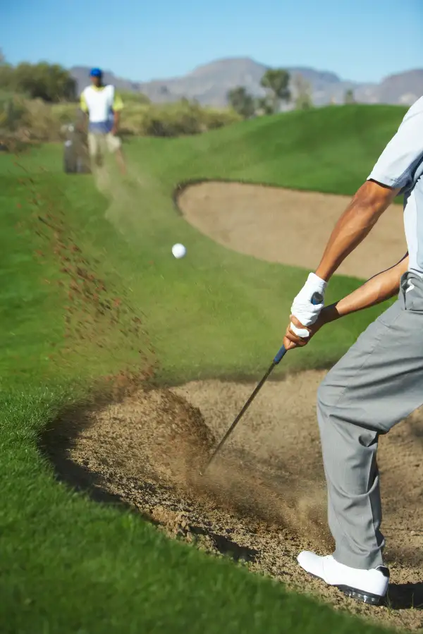 digging golf ball out of bunker