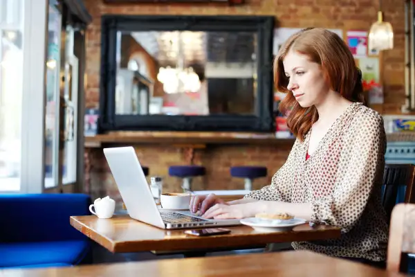 Generation X woman in coffee shop on laptop