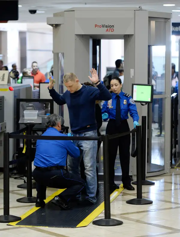 An airline passenger is patted down by a Transportation Security Administration (TSA) agent