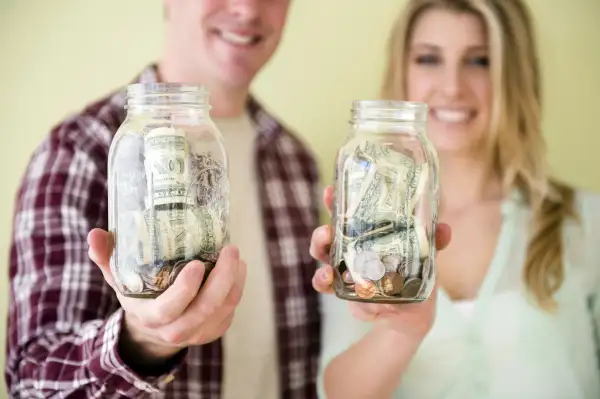 Parents showing jars of money