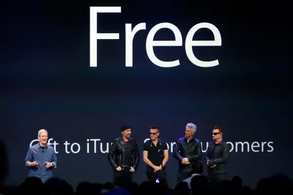 Apple CEO Tim Cook (L) stands with Irish rock band U2