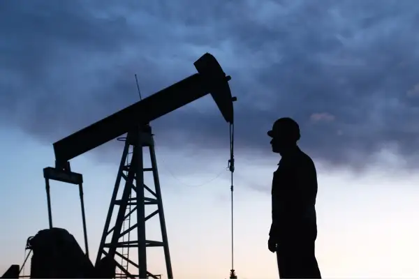 Man looking at oil rig in silhouette