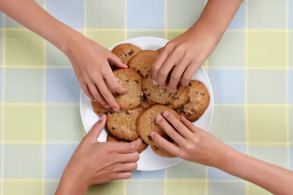 Kids taking cookies from plate