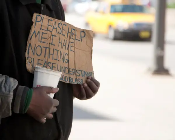 panhandler holding up sign