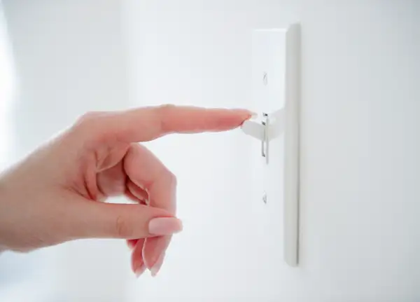 woman flicking light switch