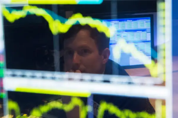 A trader watches the screen at his terminal on the floor of the New York Stock Exchange in New York October 15, 2014.