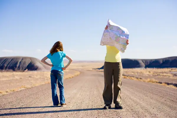 millennials looking at map on road