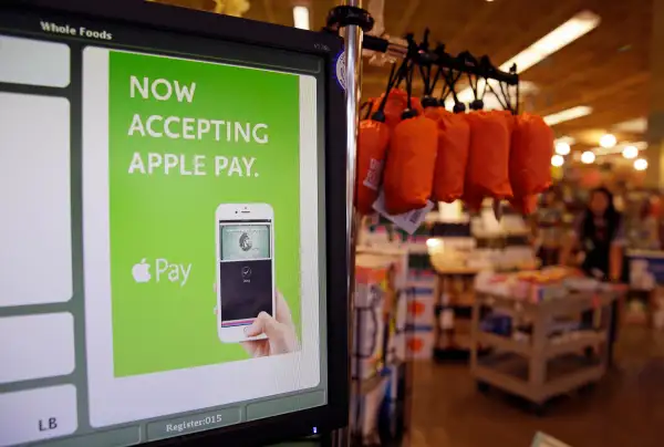 a cash register terminal promotes usage of the new Apple Pay mobile payment system at a Whole Foods store in Cupertino, Calif.