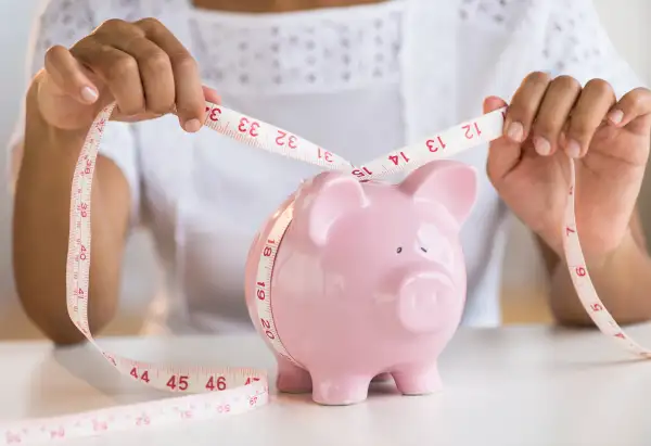 seamstress measuring a piggy bank