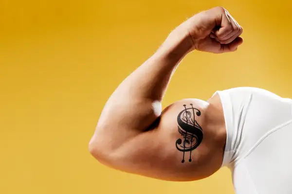 Man flexing arm with $ tattoo on it