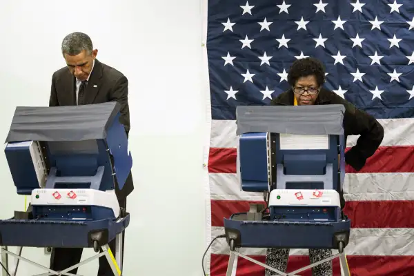 President Barack Obama(L) casts a ballot in early voting for the 2014 midterm elections at the Dr. Martin Luther King Community Service Center October 20, 2014 in Chicago, Illinois. The President took a break from campaigning for Democratic Governor Pat Quinn to cast his vote.