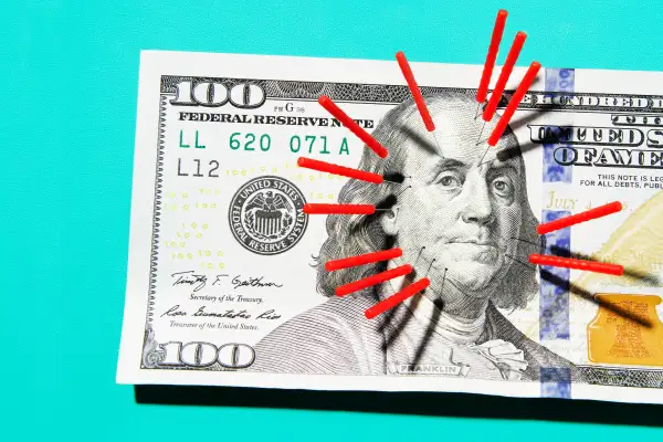 Acupuncture needles stuck in $100 bill