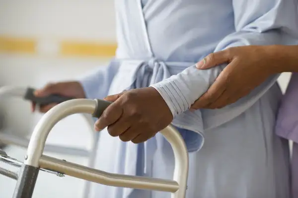 woman helping woman with walker