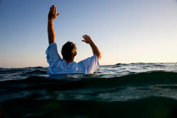 man overboard waving arms in the air for help