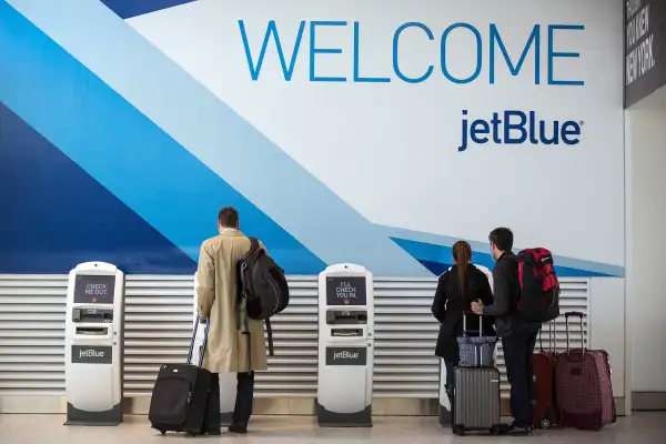 Customers check in at JetBlue's counter at John F. Kennedy Airport in the Queens borough of New York City.