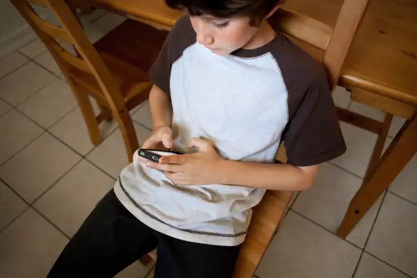 boy on smartphone in kitchen