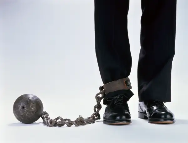 man with ball & chain attached to leg