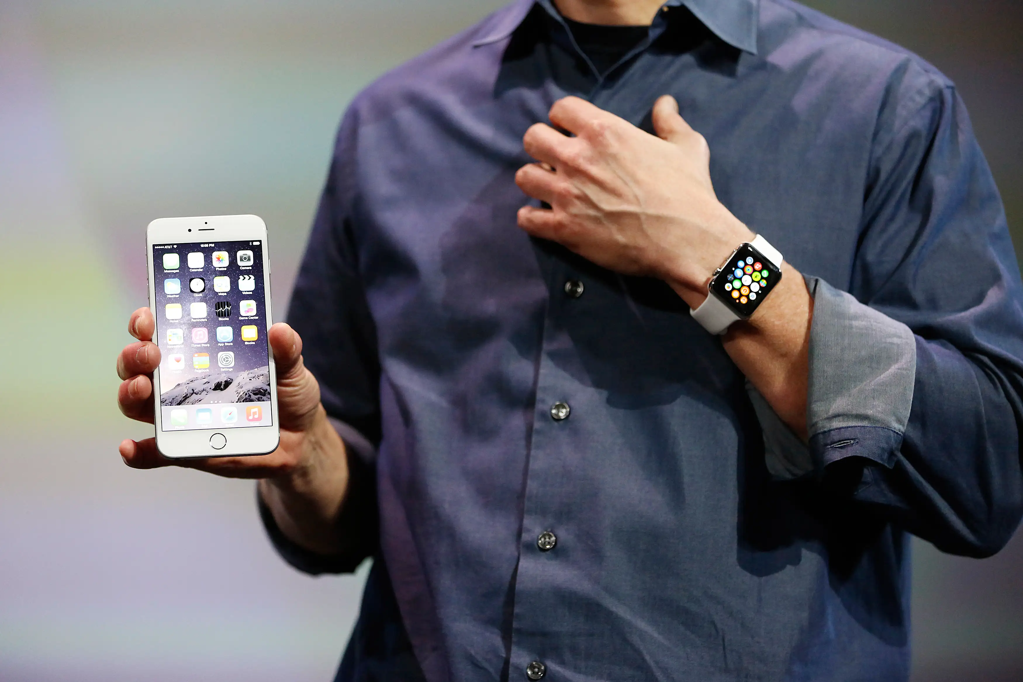 Apple CEO Tim Cook wears the Apple Watch and shows the iPhone 6 Plus during an Apple event at the Flint Center in Cupertino, California, September 9, 2014.