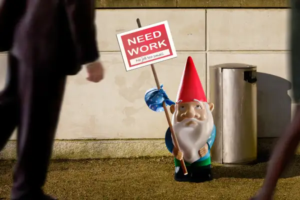 Garden gnome with  need work  sign