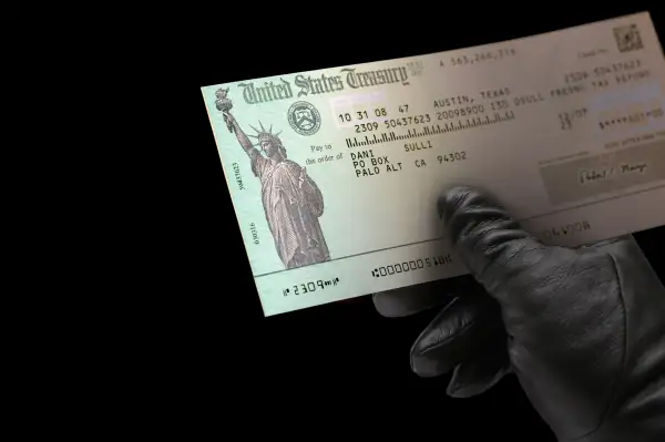 black glove holding US Treasury check