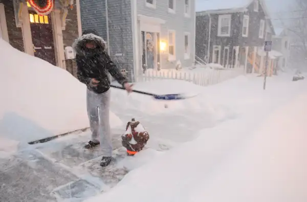 Shalonda Earvin clears the sidewalk in front of her Union St. home in Norwich, Conn., Tuesday, Jan. 27, 2015. Earvin said this was her fourth time out shoveling since it started snowing.