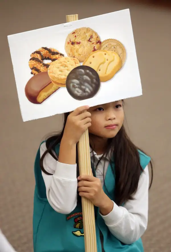 Ashley Rubin, 9, holds a sign during Girl Scout Troop 582's cookie training session at Beach Vineyard Church in Panama City Beach, Florida, 2015.