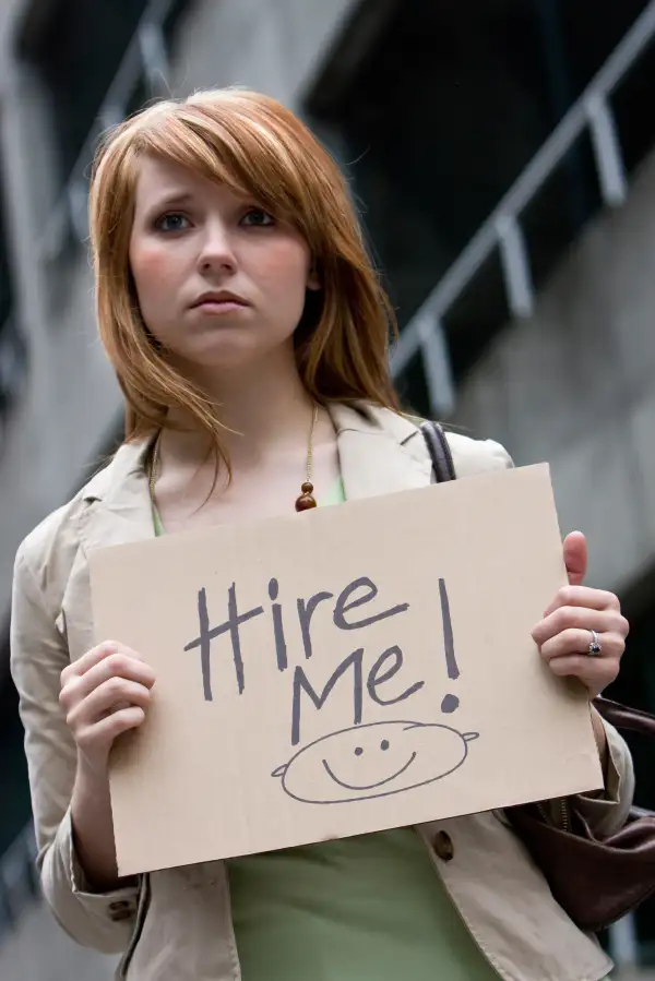 woman holding  Hire Me  sign