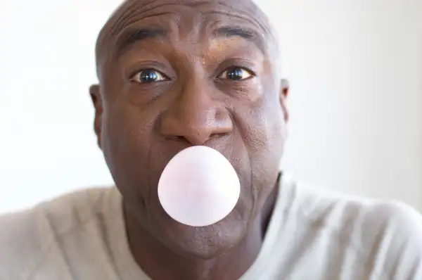 senior man blowing bubble out of gum