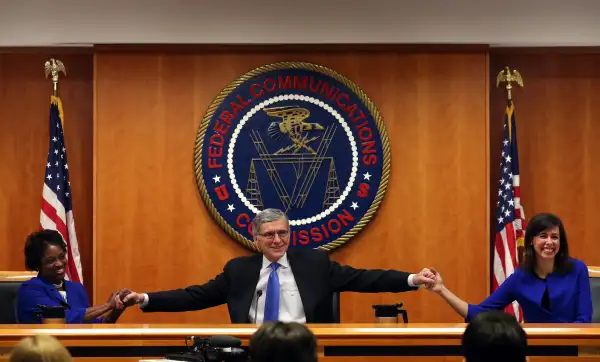 Federal Communications Commission Chairman Tom Wheeler (C) holds hands with FCC Commissioners Mignon Clyburn (L) and Jessica Rosenworcel during an open hearing on Net Neutrality at the FCC headquarters February 26, 2015 in Washington, DC. Today the FCC will vote on Net Neutrality seeking to approve regulating Internet service like a public utility, prohibiting companies from paying for faster lanes on the Internet.