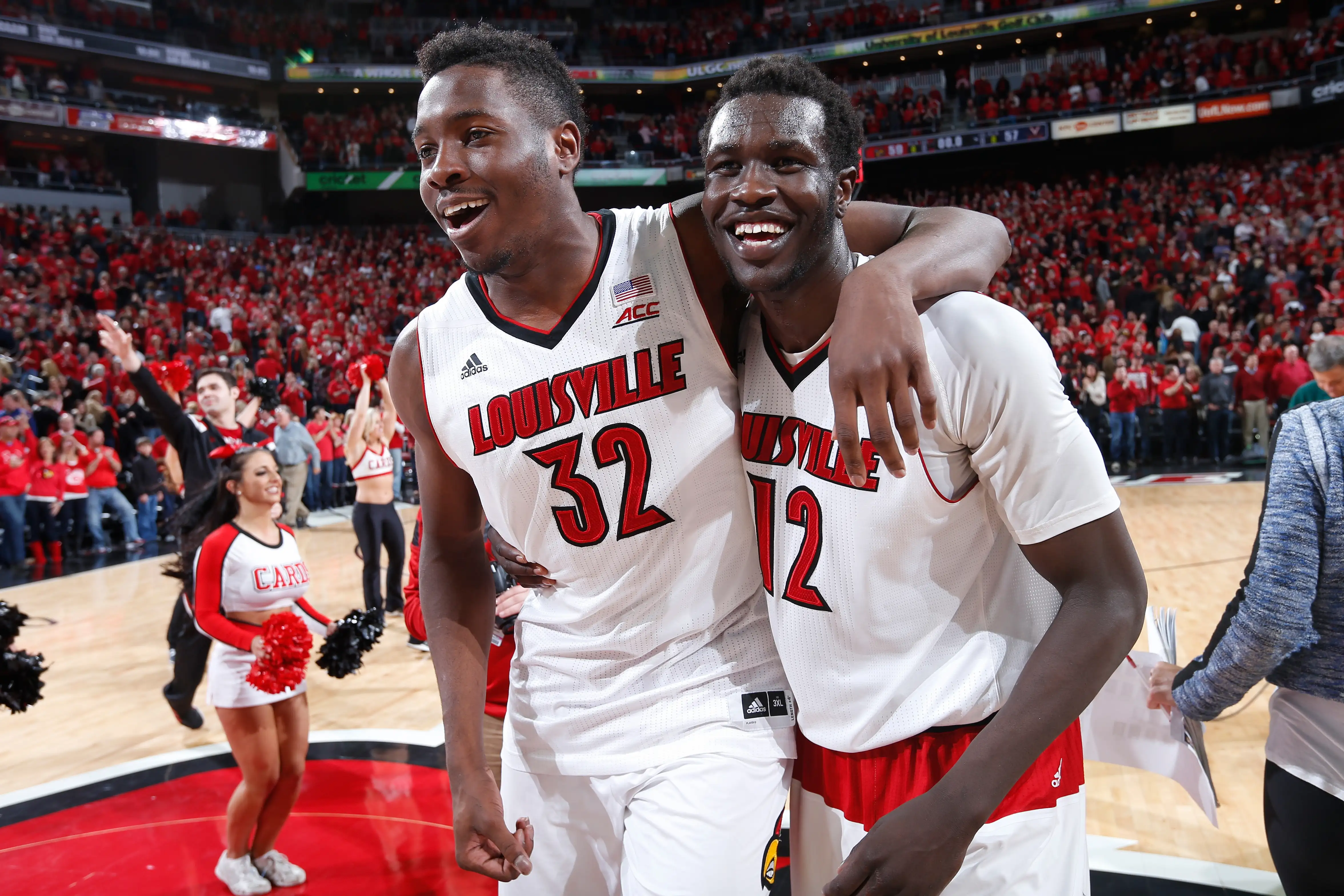 Mangok Mathiang #12 of the Louisville Cardinals celebrates his winning basket with teammate Chinanu Onuaku #32 after the game against the Virginia Cavaliers at KFC Yum! Center on March 7, 2015 in Louisville, Kentucky. Louisville defeated Virginia 59-57.