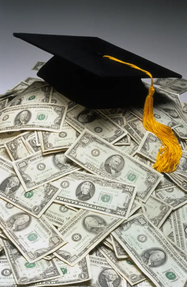 mortarboard on top of pile of cash