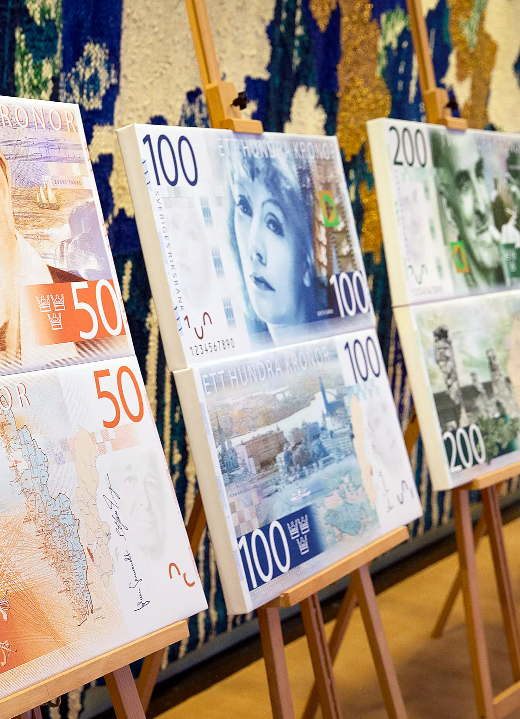 Artwork showing the designs of new folding Swedish krona, or kronor, currency notes due to be issued in 2014 stands on display at the Riksbank in Stockholm, Sweden, on Tuesday, Jan. 22, 2013.