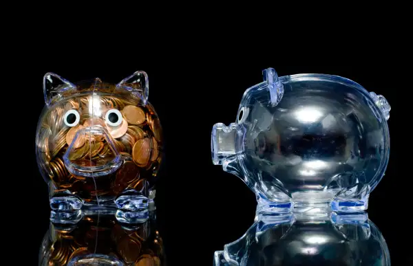 empty and full transparent piggy banks