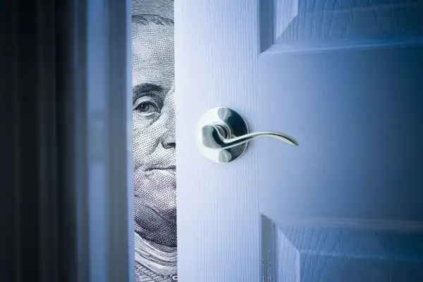 door opening with Franklin $100 staring through the crack