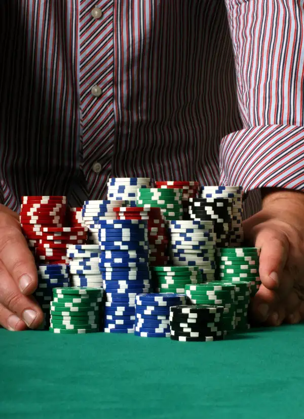 hands pushing poker chip stacks on table