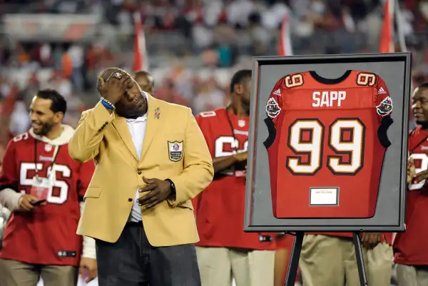 Former Tampa Bay Buccaneers defensive tackle Warren Sapp wipes his face as he is inducted into the team's Ring of Honor during half time in an NFL football game against the Miami Dolphins Monday, Nov. 11, 2013, in Tampa, Fla.