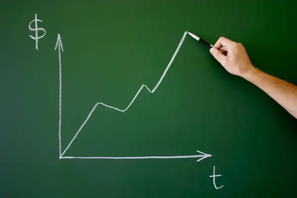 chalkboard with graph showing increase in money over time