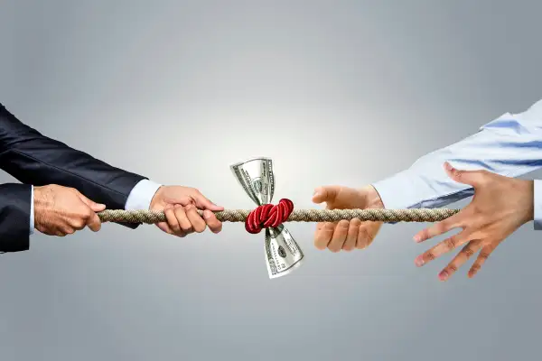 tug of war over money, one person letting go of rope