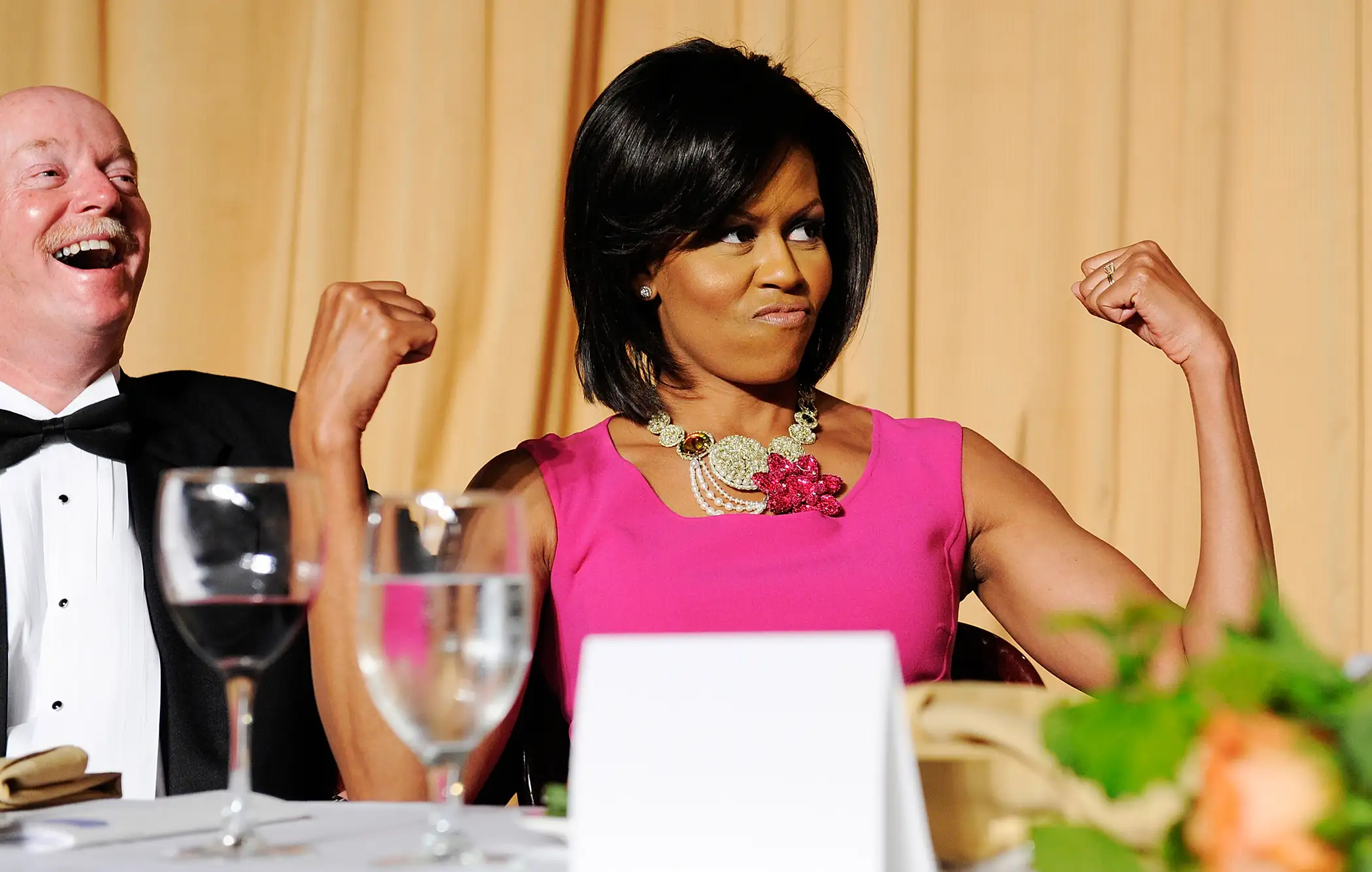 U.S. first lady Michelle Obama flexes her arms in response to a joke about her habit of wearing sleeveless dresses during the White House Correspondents' Association Dinner in Washington May 9, 2009.