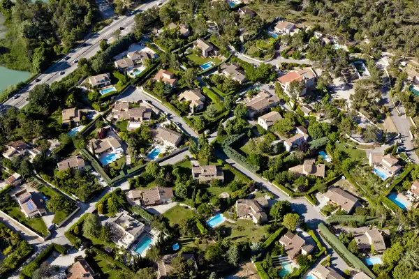 aerial view of homes with green lawns and pools