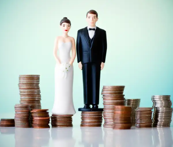 wife and groom figurines on piles of change