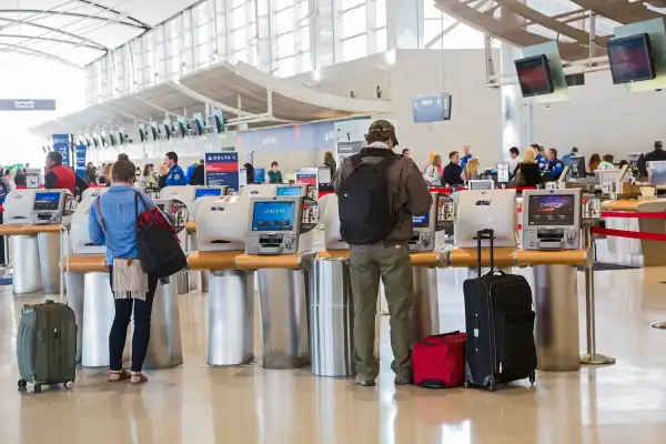 Passengers use self-service machines to check in for flights on Delta Air Lines at Detroit Metro Airport.